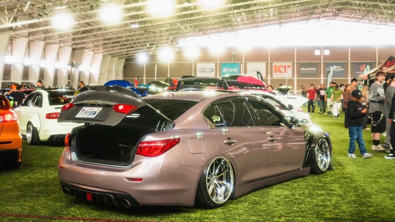 Car on display at an indoor car show with people around